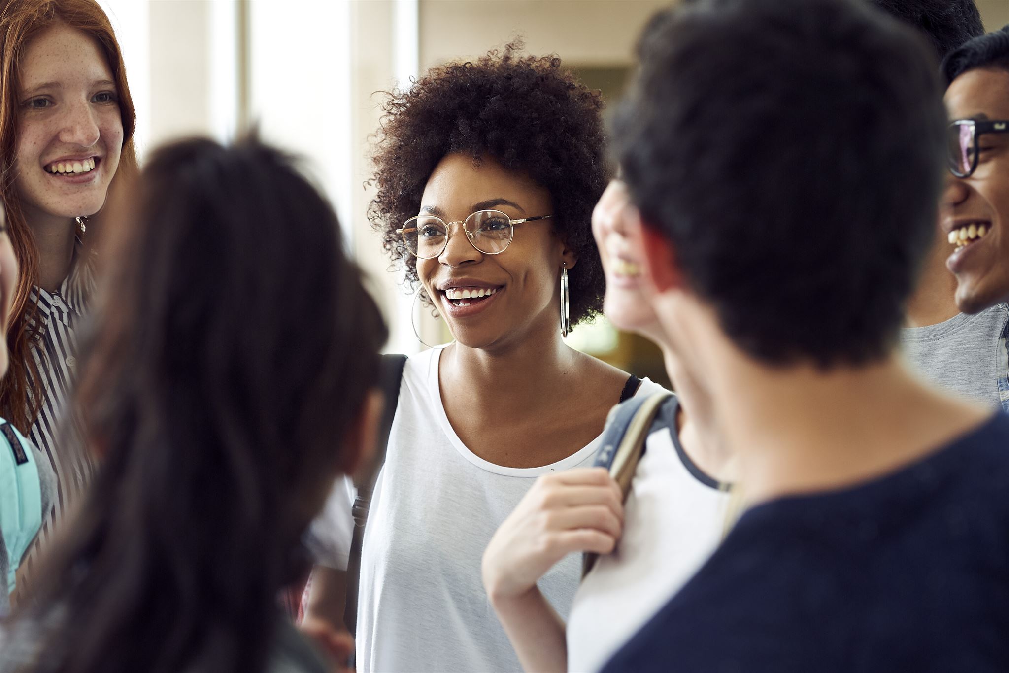 Smiling-students-chatting-in-school-corridor